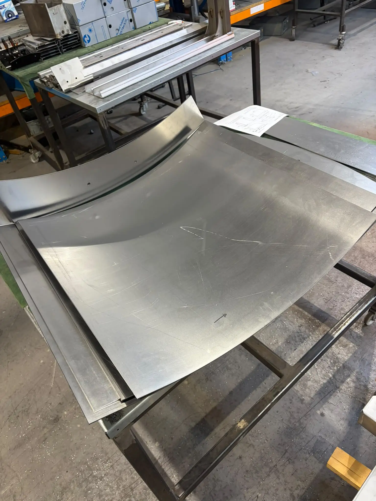 Formed curved panels for the dining table bases laid out on a trolley next to the drawing