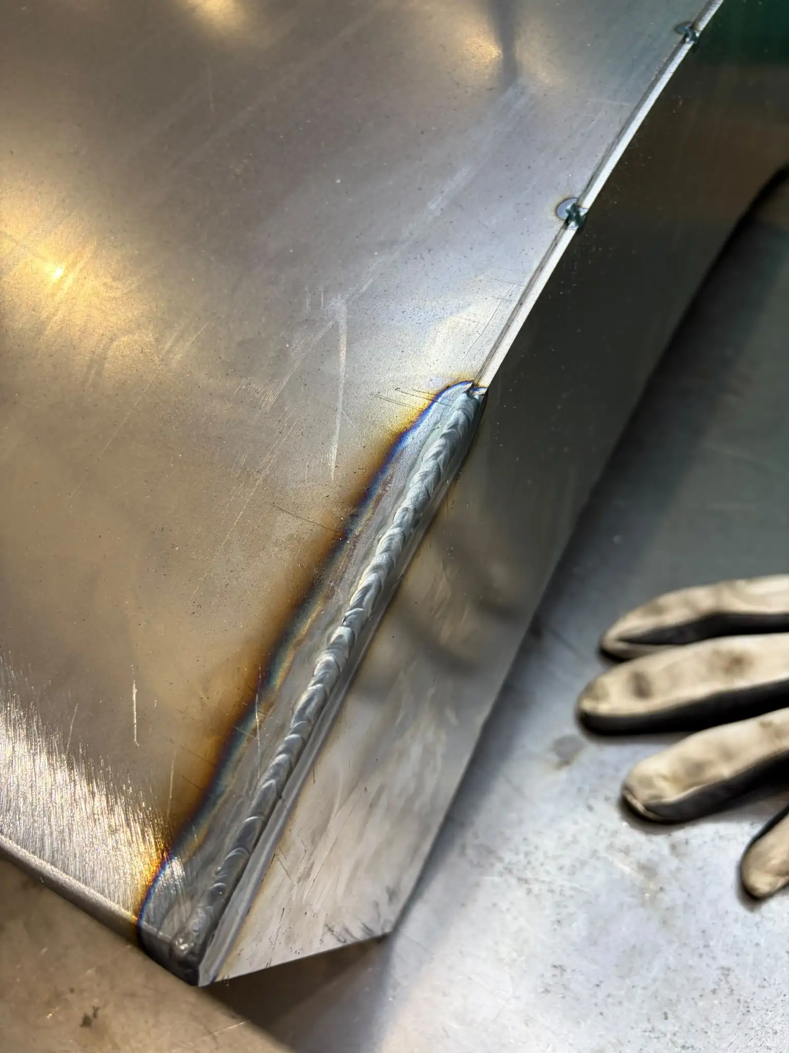 Close-up of a welded corner seam on a curved dining table base