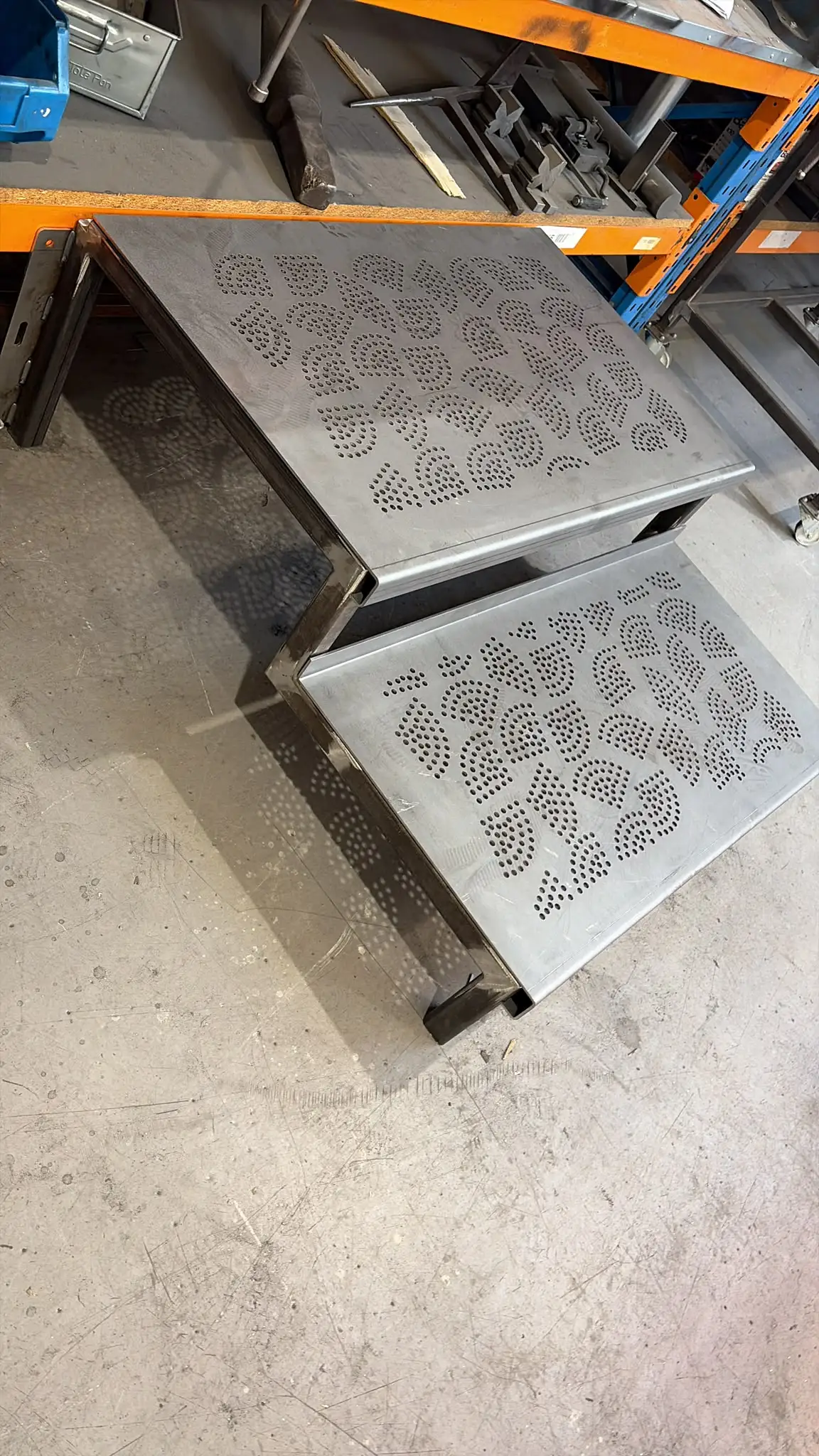 Bespoke two-tread steps on the workshop floor, with decorative patterned treads and folded edges