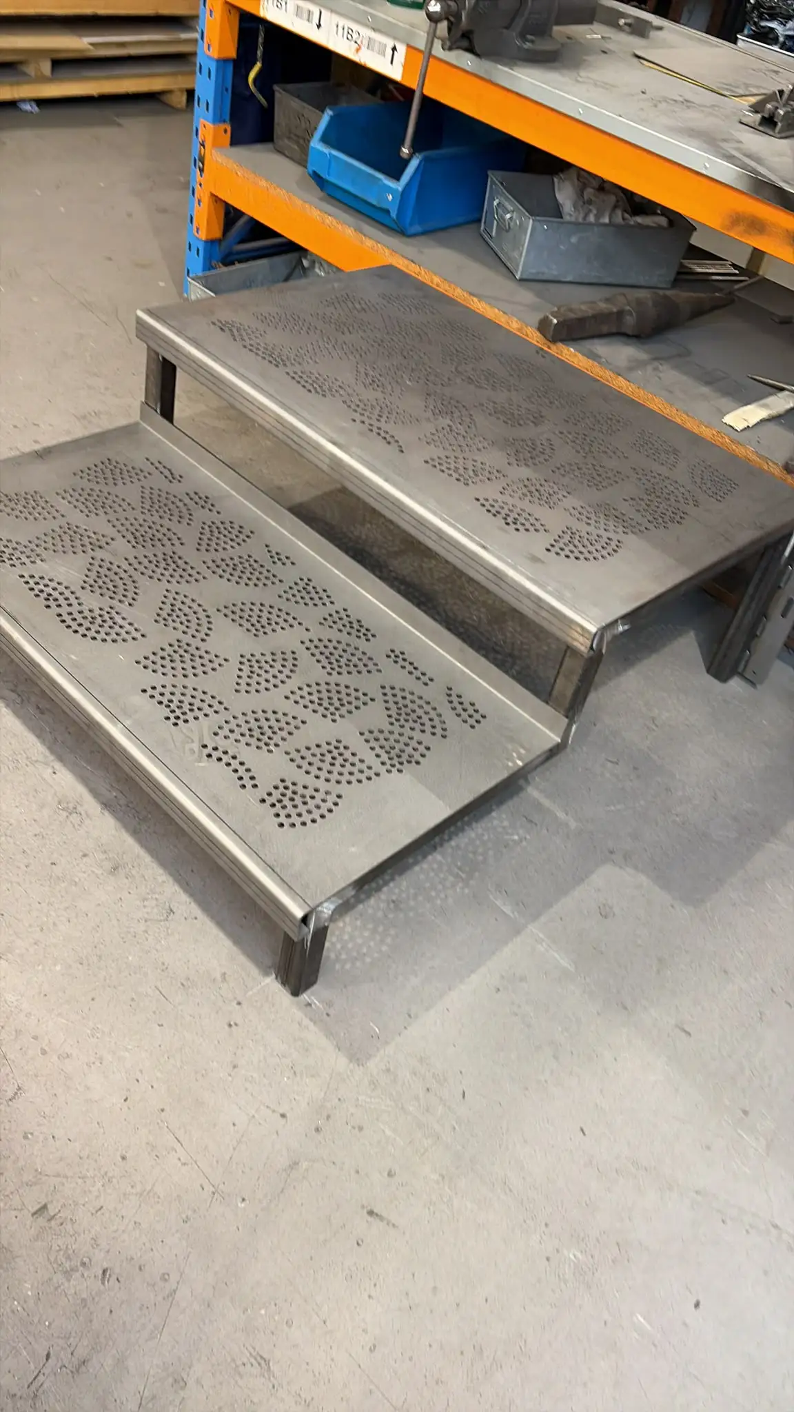 Side view of high-end steps with patterned treads standing in the workshop