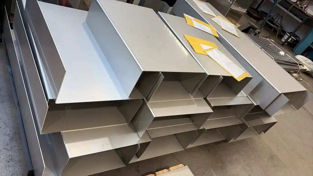 Grid of unfinished industrial magnet cases on the workshop floor, with job paperwork on the top row