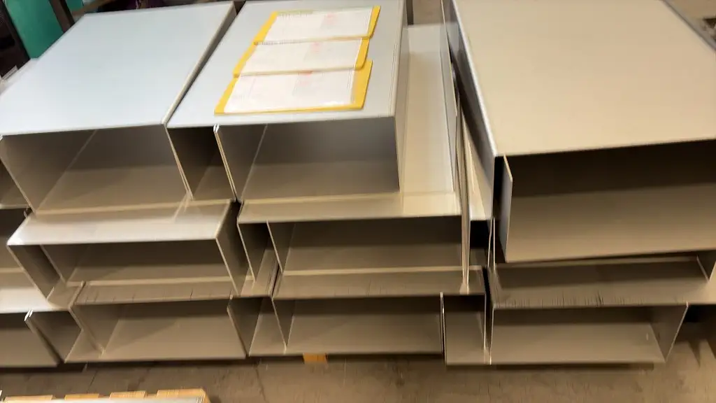 Production run of folded stainless magnet cases with job folders on top of the stack