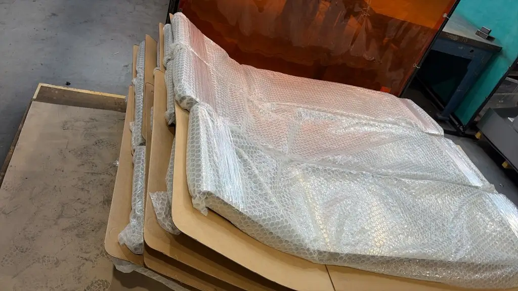 Finished playground slides stacked and packed in bubble wrap and cardboard on the workshop floor