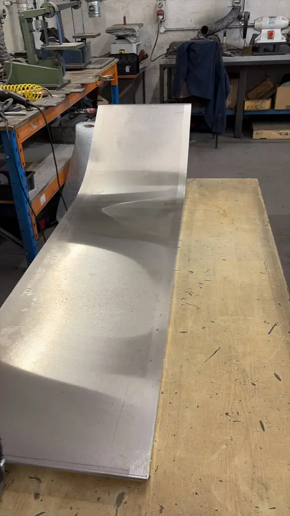 Long fabricated slide sheet on the bench, rolled to a smooth curve and skillfully finished