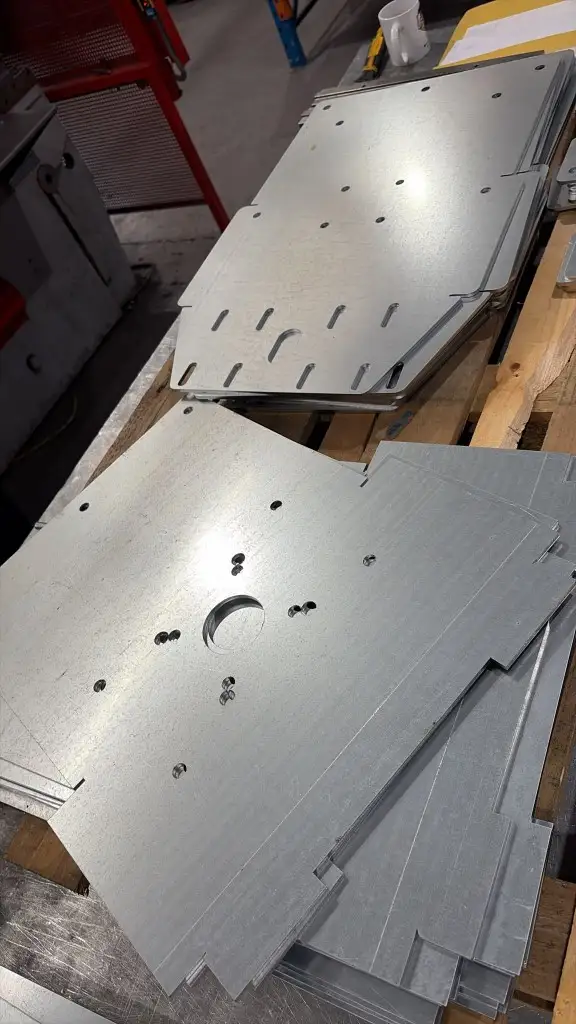 Stacks of flat galvanised shutter hardware, nitrogen laser cut with a clean edge and mounting slots