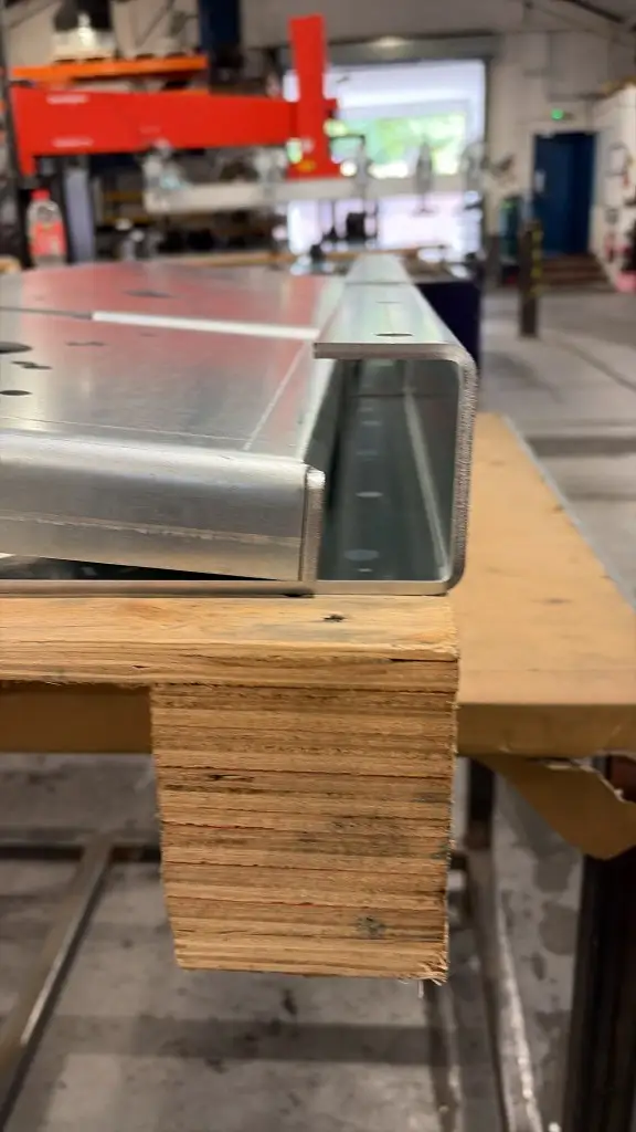 Close-up of a galvanised C-channel and flanged plate showing the clean nitrogen laser-cut edge