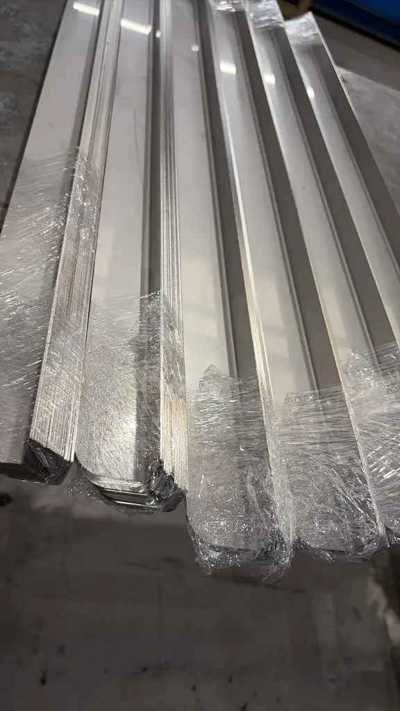 Rows of nested fabricated L-angles, ends stretch-wrapped and ready for dispatch