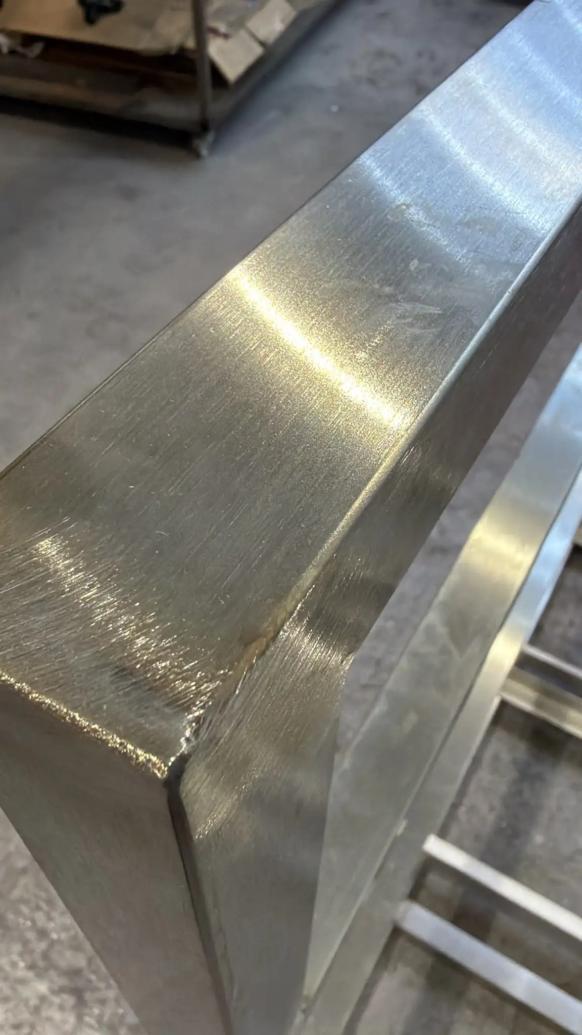 Close-up of a dressed TIG weld at the corner of a stainless steel tube frame